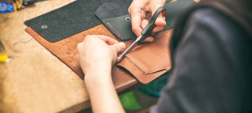 The young woman works with leather The young woman works with leather